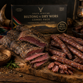 Large South African dry wors and biltong combo on a rustic wooden surface